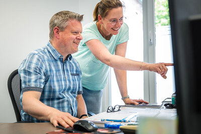 Mitarbeiter von Elektro Wehren tauschen sich am PC aus
